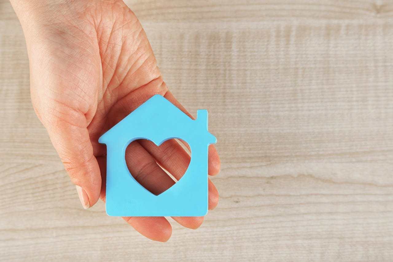 type of senior care - An image of a hand holding a home in the shape of a heart.