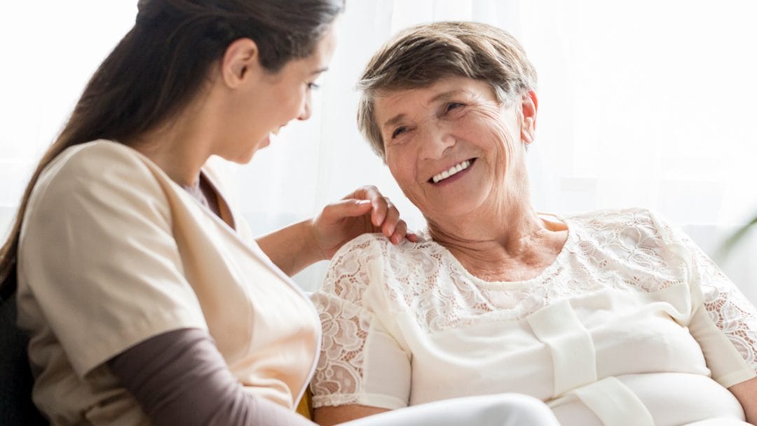 A caregiver having a pleasant conversation with a senior woman