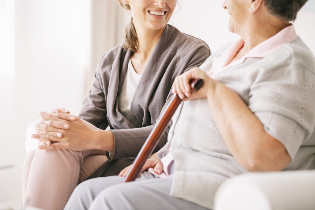 An elder woman talking with a caregiver